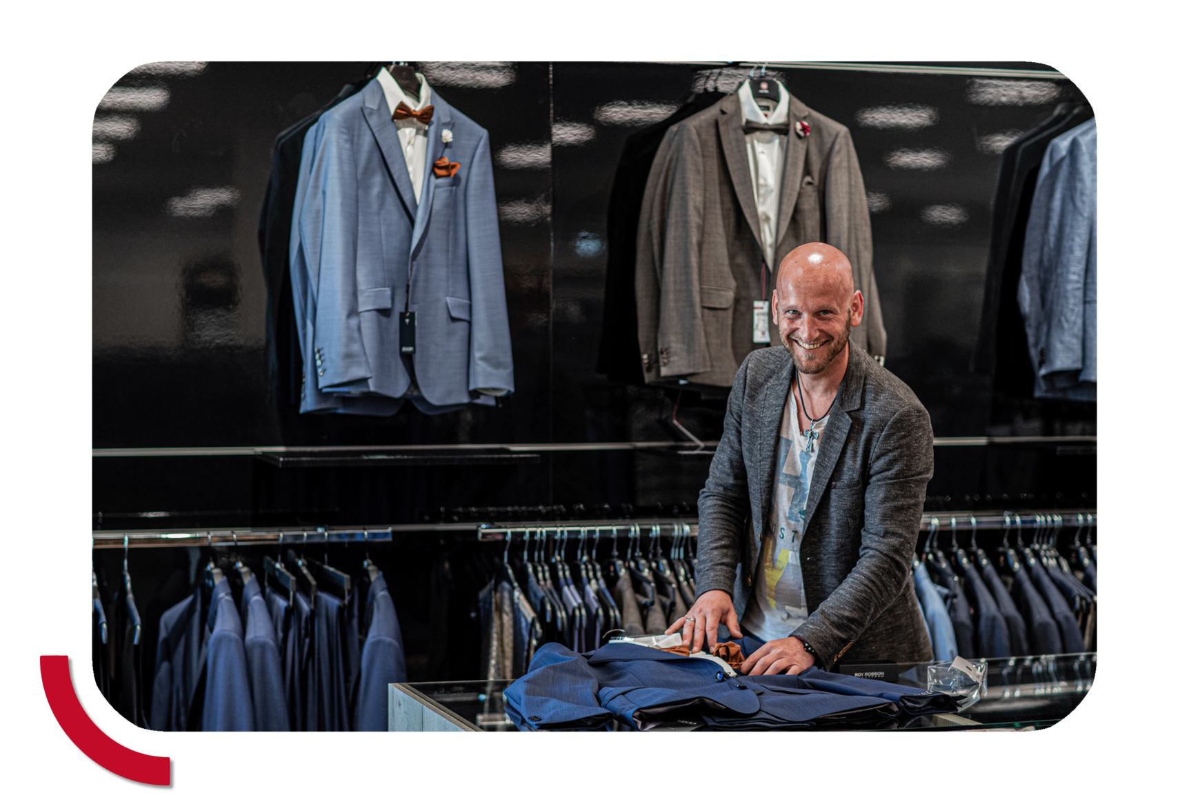 Mitarbeiter faltet Sakko in der Herrenabteilung