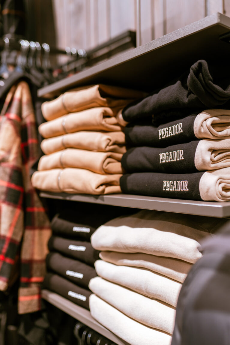 Kleidung der Marke Pegador im Modegeschäft sortiert