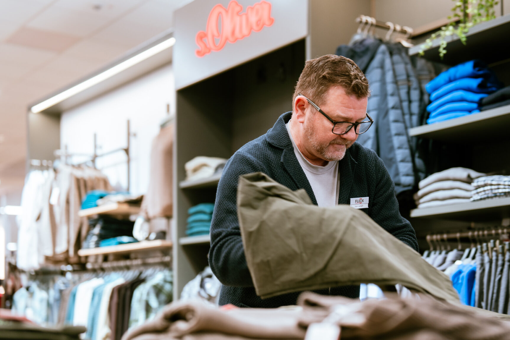 Mitarbeiter sortiert Ware im Geschäft