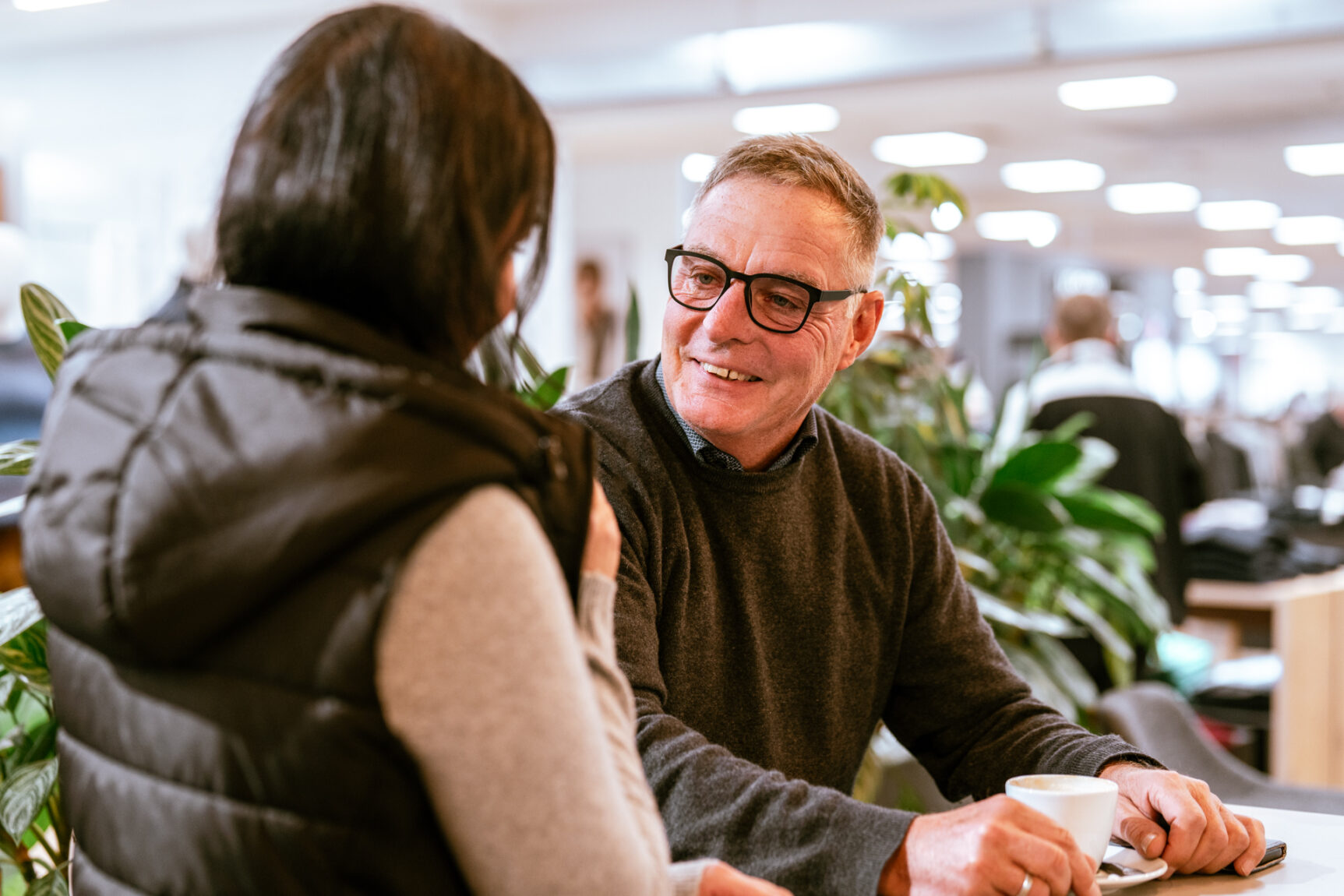 Mitarbeiterin unterhält sich freundlich mit einem Kunden